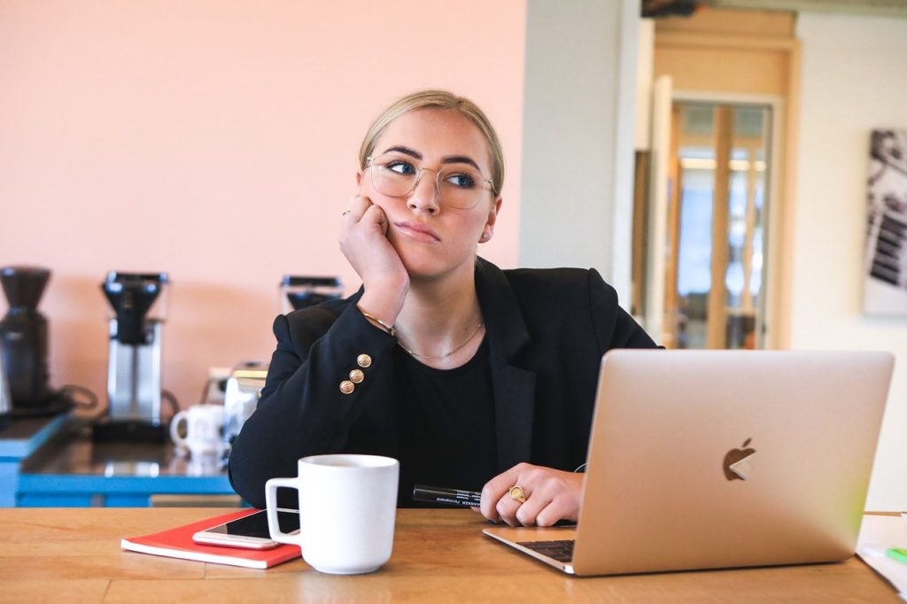 female entrepreneur desk laptop bored