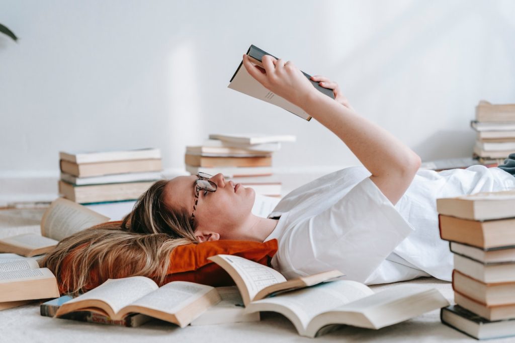 woman reading books laying down